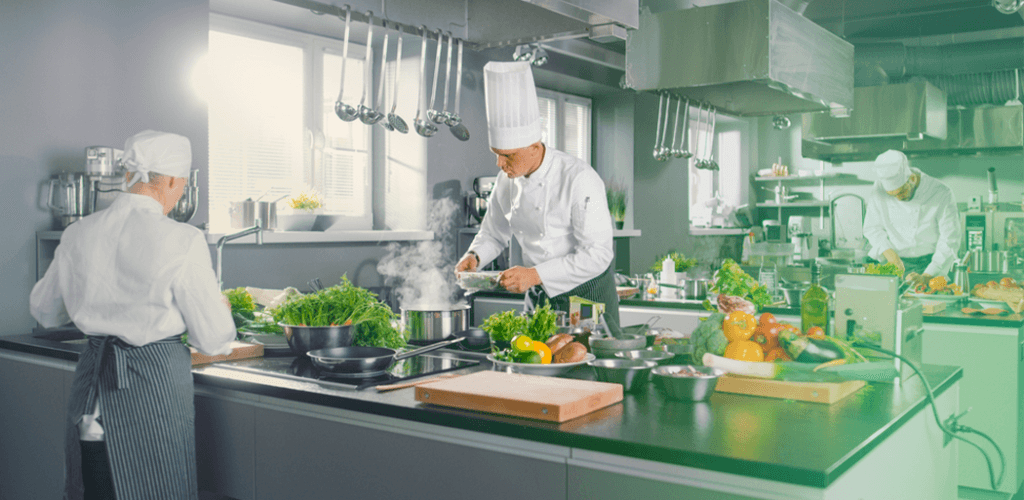 Especialistas em auditoria inspecionando a cozinha de um restaurante para garantir práticas adequadas de higiene e segurança alimentar.